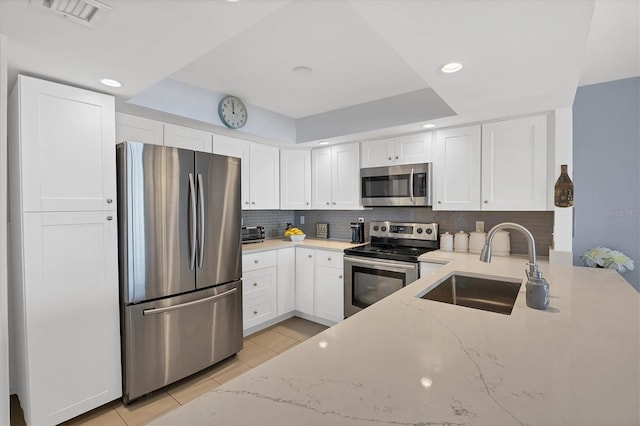 kitchen featuring light stone counters, white cabinetry, and appliances with stainless steel finishes