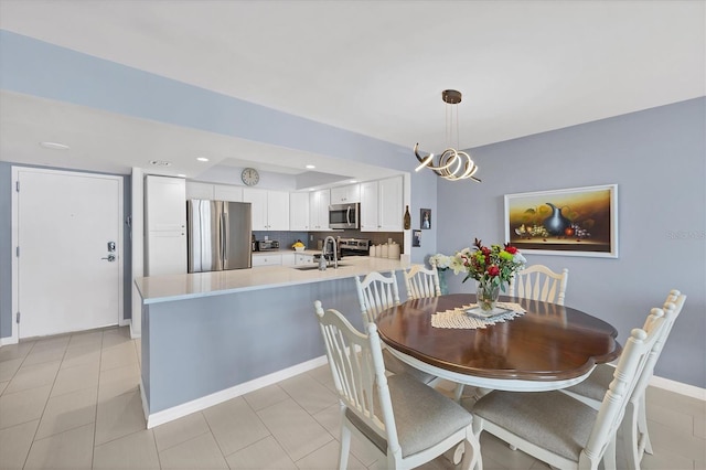 dining room with light tile patterned flooring, sink, and an inviting chandelier