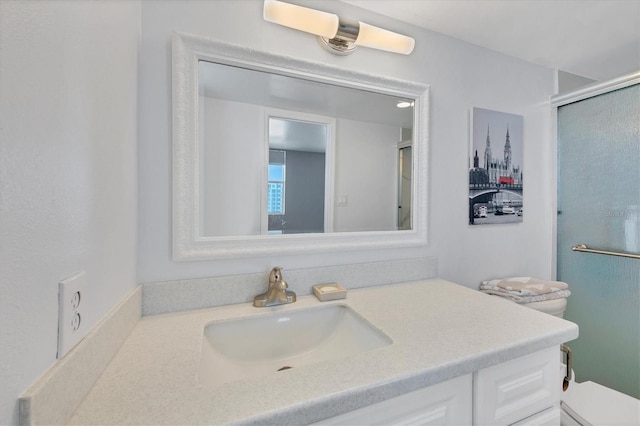 bathroom with a shower with door, vanity, and toilet