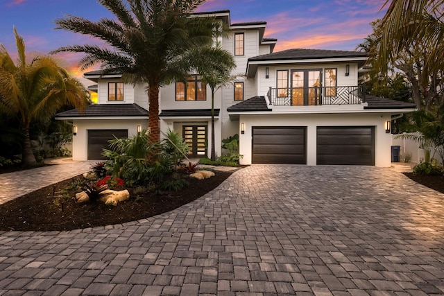 view of front of property with french doors, a balcony, and a garage