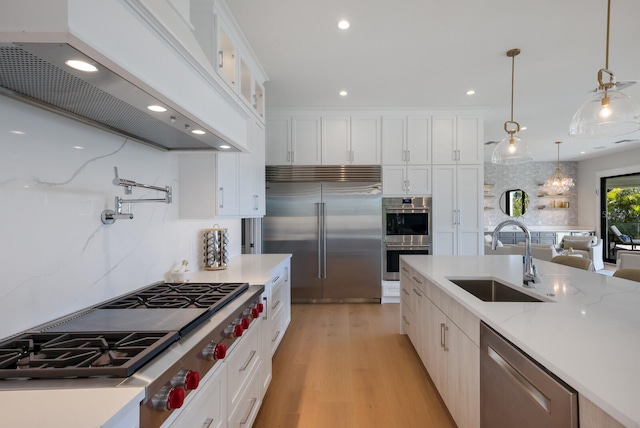 kitchen featuring white cabinetry, sink, stainless steel appliances, pendant lighting, and custom exhaust hood