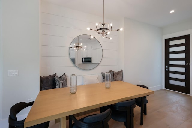 dining room with hardwood / wood-style floors and an inviting chandelier