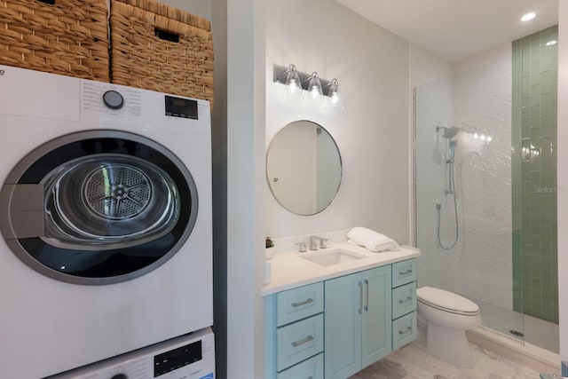 bathroom with toilet, vanity, stacked washing maching and dryer, and tiled shower