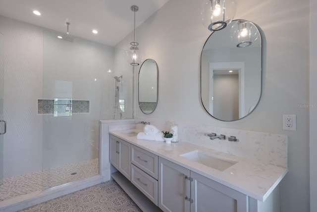 bathroom featuring a tile shower, vanity, and tile patterned floors