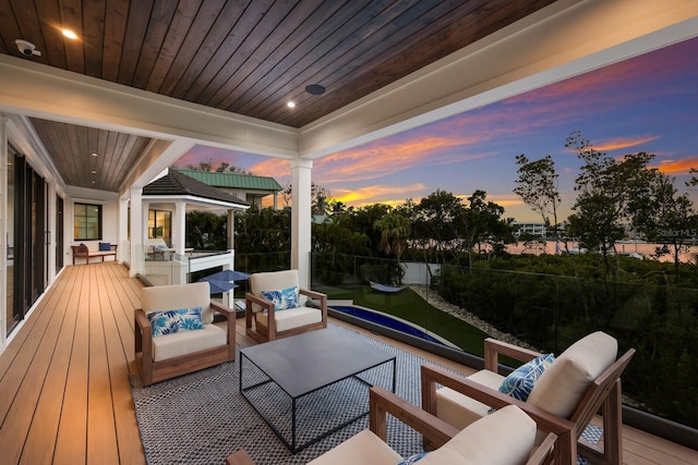 patio terrace at dusk featuring an outdoor living space and a balcony