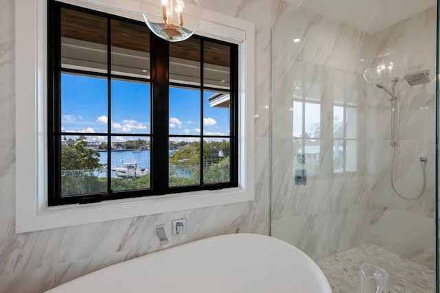 bathroom featuring a water view, a wealth of natural light, and independent shower and bath