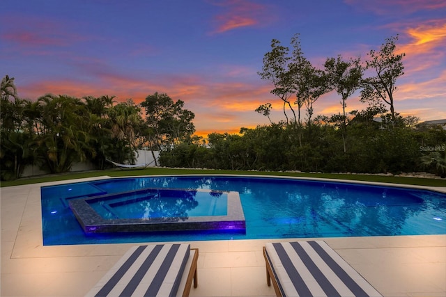 pool at dusk featuring an in ground hot tub