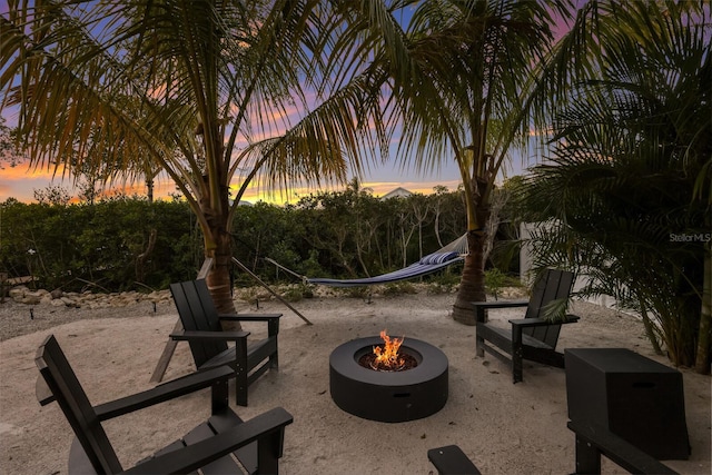 surrounding community featuring an outdoor fire pit and a patio area