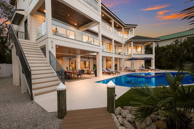 pool at dusk featuring a patio area