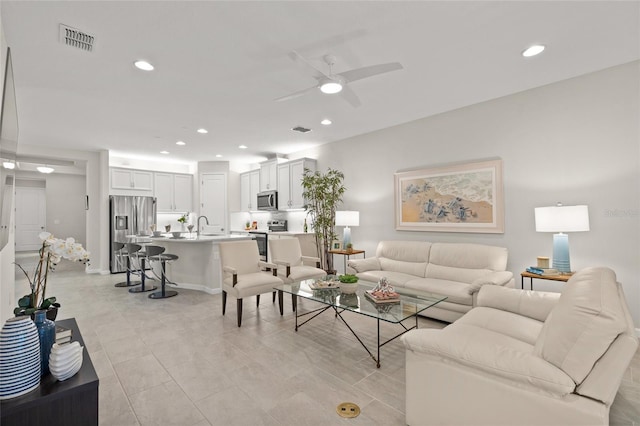 living room featuring ceiling fan and sink