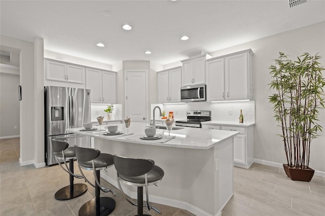 kitchen featuring white cabinets, an island with sink, stainless steel appliances, and sink