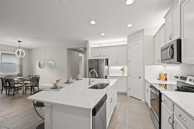 kitchen with a center island with sink, sink, white cabinetry, and stainless steel appliances