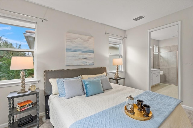 carpeted bedroom featuring ensuite bath