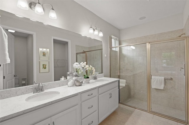 bathroom featuring tile patterned floors, vanity, toilet, and a shower with shower door