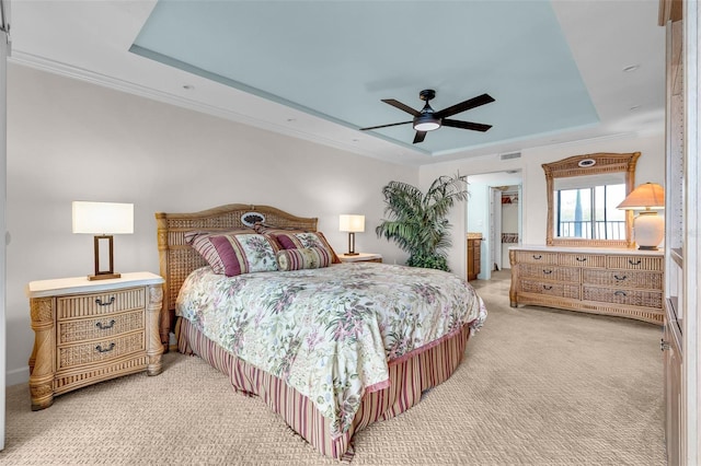 carpeted bedroom featuring ceiling fan, ornamental molding, and a raised ceiling