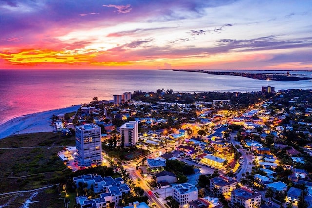 aerial view at dusk featuring a water view