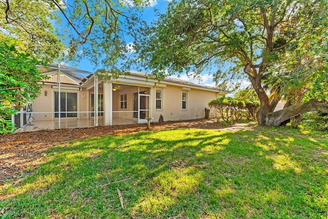 108 Corte Del Rosa, Venice, FL 34285 - back of house with stucco siding, a yard, and a ceiling fan