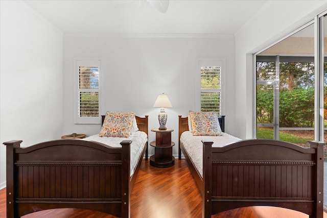 bedroom with crown molding and dark wood-type flooring