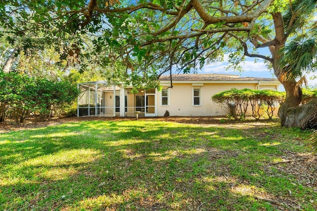 108 Corte Del Rosa, Venice, FL 34285 - back of house featuring stucco siding, a lawn, and a lanai