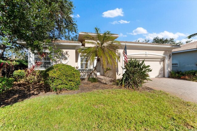 108 Corte Del Rosa, Venice, FL 34285 - view of front of property featuring a garage, decorative driveway, stucco siding, and a front yard