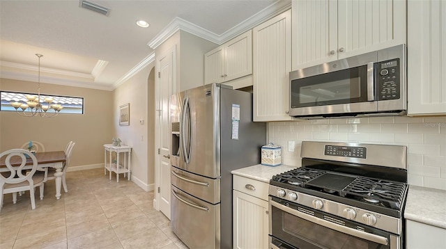 kitchen with stainless steel appliances, an inviting chandelier, tasteful backsplash, decorative light fixtures, and light tile patterned floors