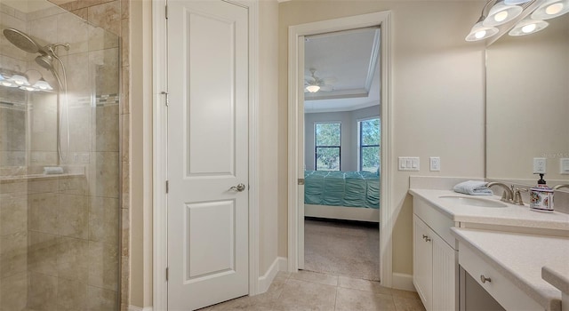 bathroom with a tile shower, ceiling fan, tile patterned floors, vanity, and ornamental molding