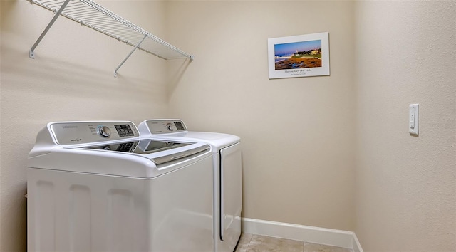 clothes washing area with light tile patterned floors and washing machine and clothes dryer