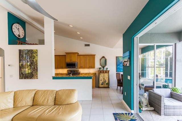 kitchen with stainless steel appliances, kitchen peninsula, high vaulted ceiling, and light tile patterned floors