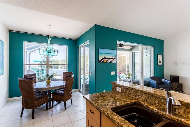 kitchen with a healthy amount of sunlight, dark stone countertops, sink, and pendant lighting