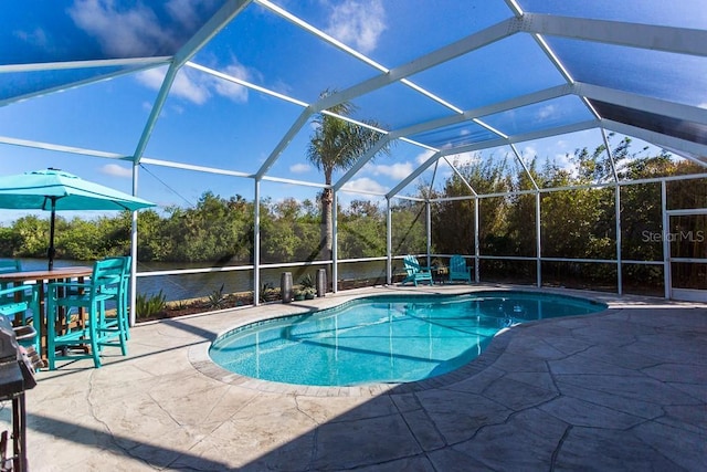 view of swimming pool featuring a patio, a water view, and glass enclosure