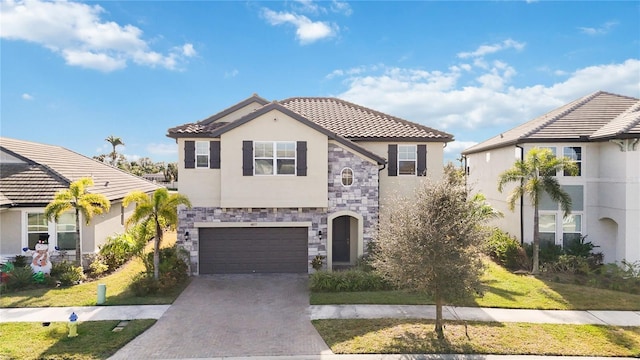 mediterranean / spanish-style house featuring a garage and a front lawn