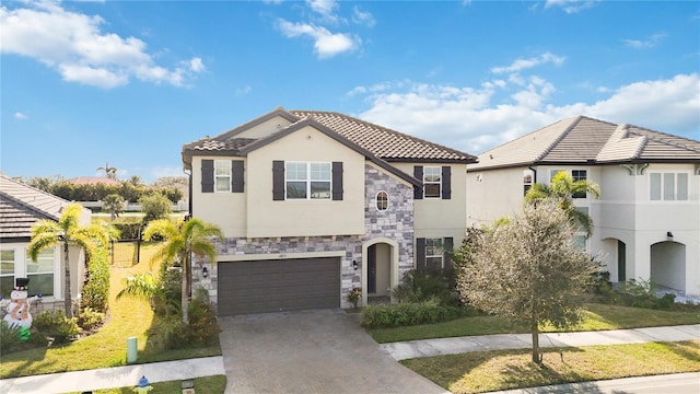 mediterranean / spanish home featuring a front yard and a garage