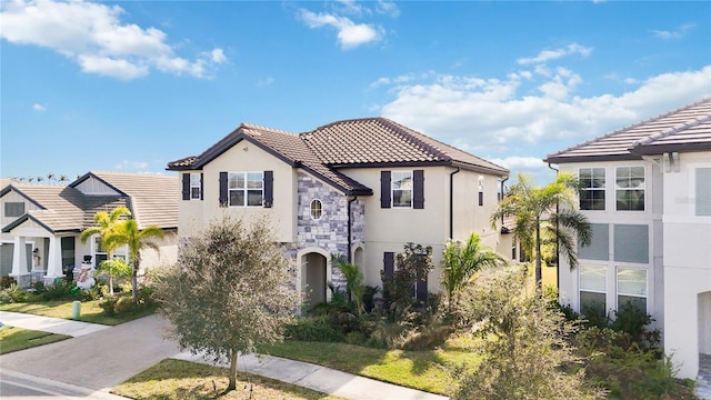 mediterranean / spanish home with a front yard