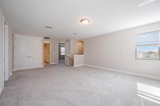 unfurnished room featuring light colored carpet and a wealth of natural light