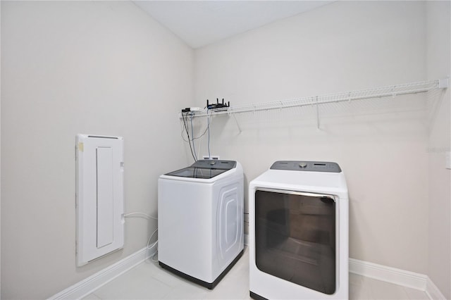 laundry room featuring light tile patterned floors and separate washer and dryer