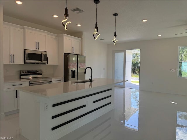 kitchen featuring sink, white cabinetry, an island with sink, and appliances with stainless steel finishes