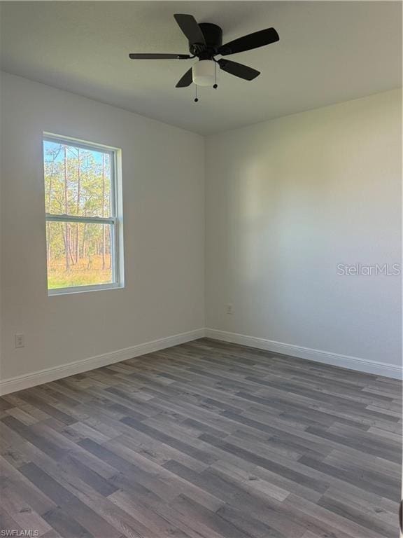 unfurnished room featuring ceiling fan and dark hardwood / wood-style flooring