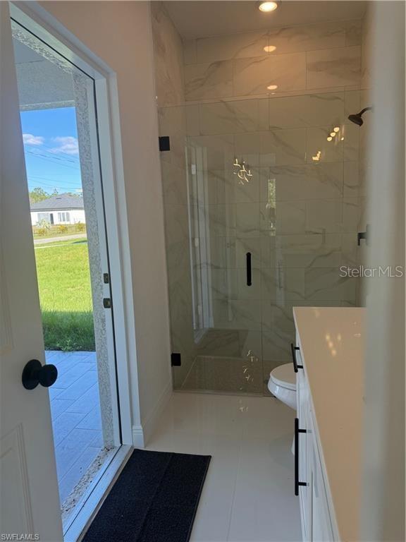 bathroom with vanity, an enclosed shower, tile patterned floors, and toilet