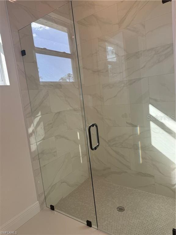 bathroom with a shower with door