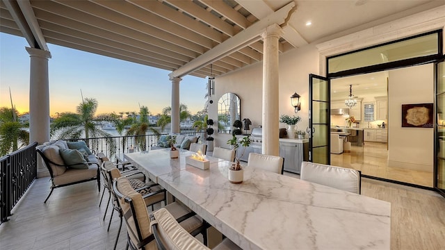 patio terrace at dusk with area for grilling, an outdoor bar, and exterior kitchen