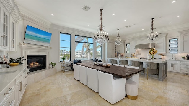 dining room with ornamental molding, sink, and a wealth of natural light