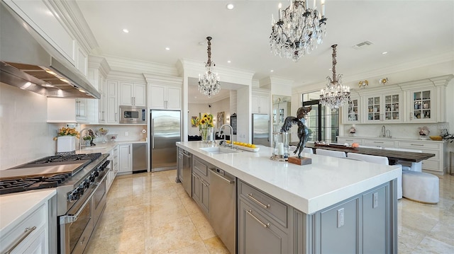 kitchen with built in appliances, tasteful backsplash, a large island, and sink