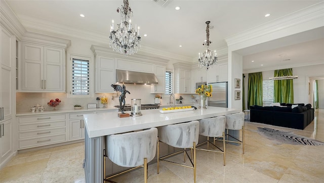 kitchen with a kitchen breakfast bar, a large island with sink, and stainless steel refrigerator