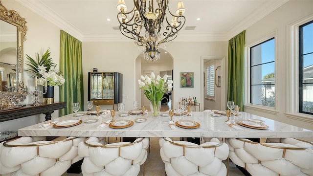 dining area featuring a chandelier, tile patterned flooring, and crown molding