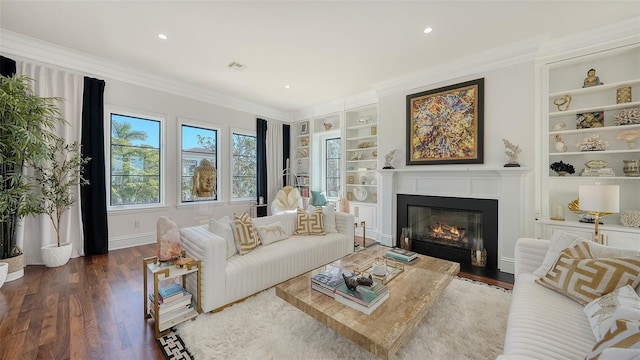 living room featuring ornamental molding, built in shelves, and dark wood-type flooring