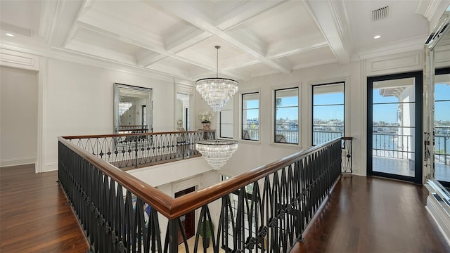 hallway with beamed ceiling, dark hardwood / wood-style flooring, coffered ceiling, and an inviting chandelier