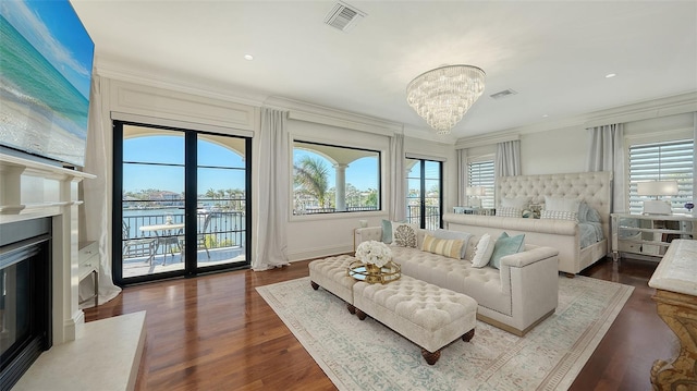 bedroom featuring access to exterior, dark hardwood / wood-style flooring, ornamental molding, an inviting chandelier, and multiple windows