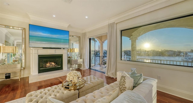 interior space with crown molding, a water view, and hardwood / wood-style flooring