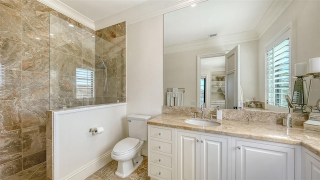 bathroom with tile patterned floors, ornamental molding, a tile shower, vanity, and toilet