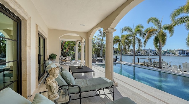 view of pool with a water view and a patio